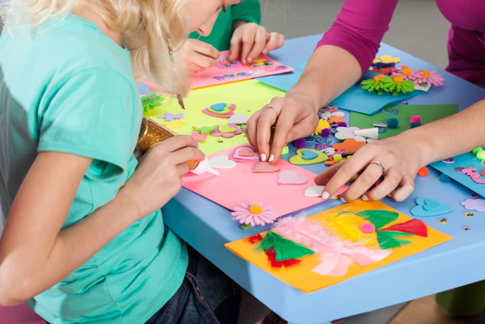 Detalle de manualidades hechas por niños y adulto con papeles recortados