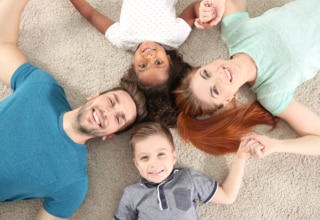 Familia: padres e hijos tumbados en el suelo en forma de círculo