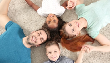 Familia: padres e hijos tumbados en el suelo en forma de círculo