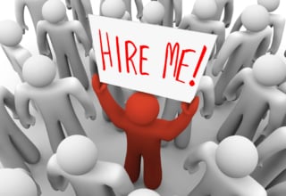 Muñeco sujetando un cartel que dice Hire me! Contráteme en inglés